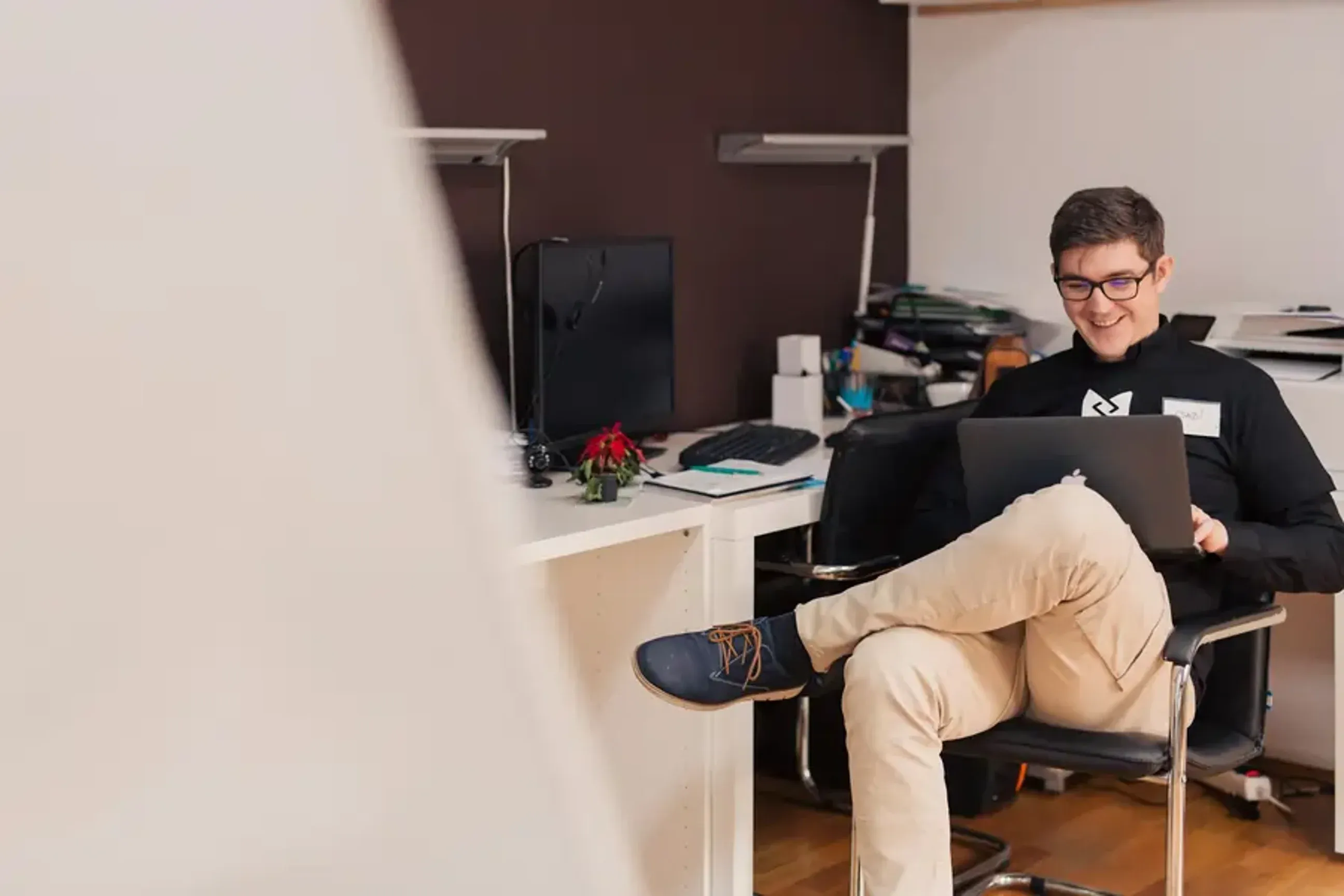 Young man sitting in a chair working on his laptop.