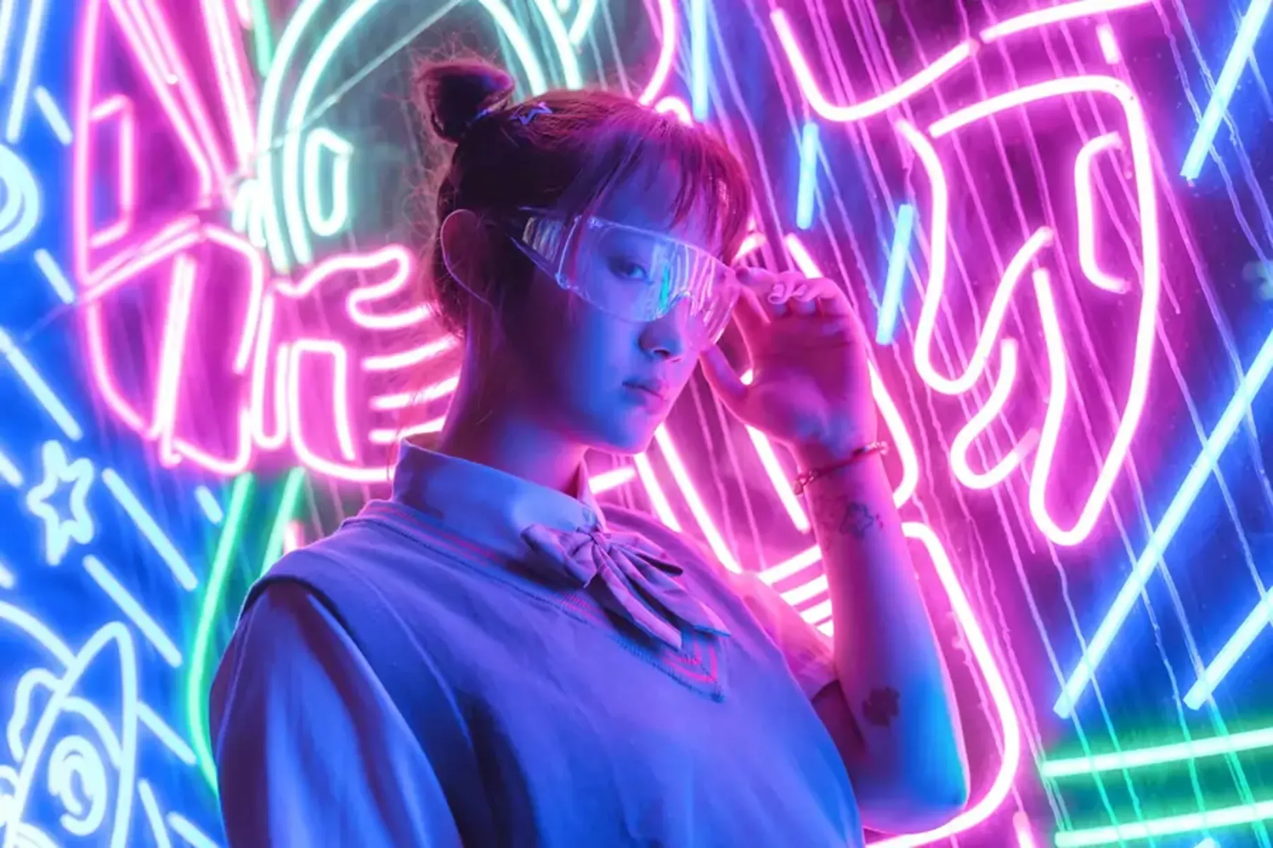 Woman wearing futuristic glasses in front of neon lights.