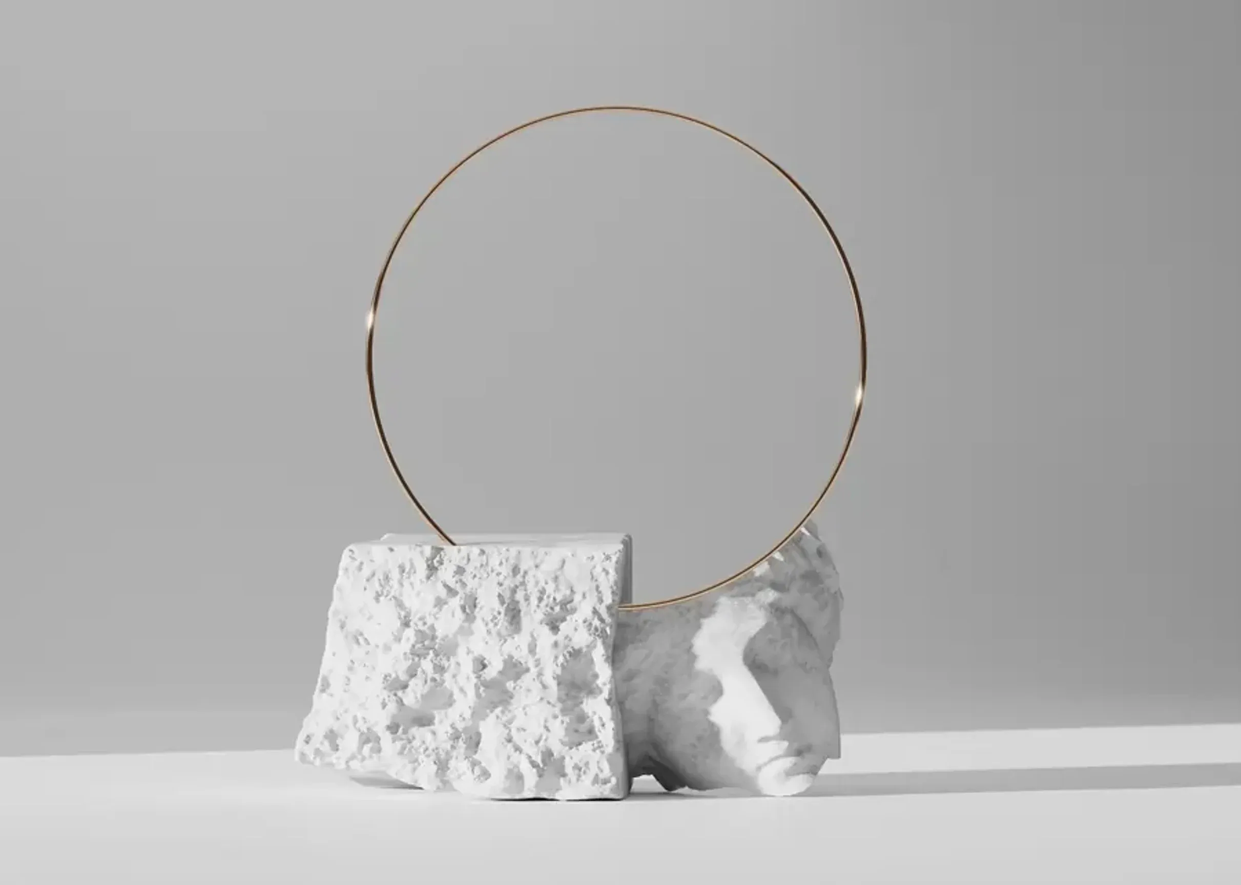Minimal abstract sculpture with a metal ring and stone base.